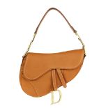 CHRISTIAN DIOR - a tan leather saddle handbag. Designed with a pebbled tan leather exterior, rear