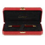 CARTIER - a Santos De Cartier ballpoint pen. Featuring a burgundy lacquered finish with a twist