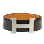 HERMÈS - a Constance H buckle belt. Crafted from smooth black leather with a tan leather underside