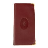 CARTIER - a Bordeaux wallet. Featuring a smooth burgundy leather exterior with maker's emblem