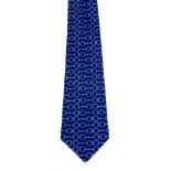 HERMÈS - a silk tie. Designed on a deep blue background with a light blue horsebit pattern. Length