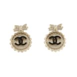 CHANEL - a pair of earrings. Each designed as a bow atop a circular panel with central black
