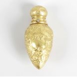 A yellow metal scent bottle, of ovoid flask form with hinged cover, decorated with repousse