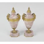 A pair of ormolu-mounted pink marble urns. Each of neoclassical form with cast domed finial over a