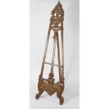 A carved and stained wooden easel, with pierced scroll decoration, 83.75 (213cm) high.