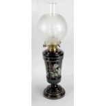 A late 19th century paraffin lamp, with frosted spherical shaped shade over black enamelled glass