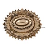 A late 19th century memorial brooch. Of oval shape, the tiered panels with applied foliate detail,