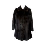 A ranch mink three-quarter length coat. Featuring a notched lapel collar, hook and eye fastenings, a