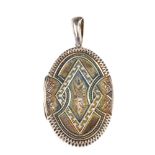 A late Victorian silver locket. Of oval outline with embossed and engraved detail to the front and