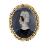 An early 19th century gold, hand painted portrait brooch. Of oval outline, the hand painted panel