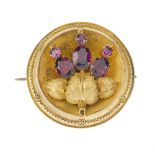 A late 19th century gold and garnet memorial brooch. Of circular outline, with central design of