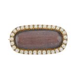 A mid Victorian gold split pearl memorial brooch. Of lozenge shape, the glazed woven hair panel,