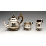 An early twentieth century composite silver three piece tea service, including a teapot, twin-