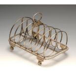 A George IV silver six-divide toast rack, the oblong form with gadrooned border to the wire looped