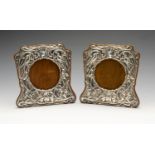 A pair of Art Nouveau silver mounted photograph frames, each decorated in relief with flowers and
