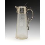 A late Victorian silver mounted glass claret jug, the oval and tapering glass body press moulded