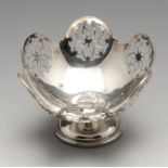 An early twentieth century silver bonbon dish with pierced circular motifs, the whole raised upon