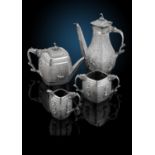 A Victorian silver four piece tea set in Indian style, comprising teapot, coffee pot, twin-handled