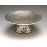 A 1920's silver tazza, of circular planished form leading to a splayed and tapered foot with applied
