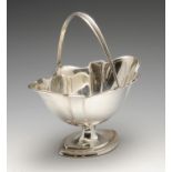 An Edwardian silver pedestal bonbon basket, the fluted oval form with shaped rim and swing handle to