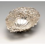A late Victorian silver dish, the oval pierced form with embossed flowers and scrolls leading to a