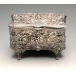 An Edwardian silver mounted jewellery casket of shaped rectangular form, ornately embossed with