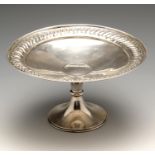 A 1930's silver pedestal dish of circular form, with embossed border leading to a slightly raised