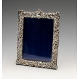 A late Victorian silver mounted photograph frame, the rectangular form with foliate scroll and shell