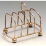 A small Edwardian silver toast rack, the five-bar simple arched form with conforming shape handle