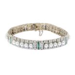 An 18ct gold cultured pearl, emerald and diamond bracelet. Designed as a series of cultured pearl
