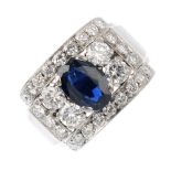 An 18ct gold sapphire and diamond ring. The oval-shape sapphire, with twin brilliant-cut diamond