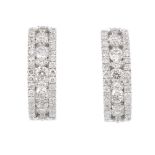 A pair of 18ct gold diamond hinged earrings. Each designed as a brilliant-cut diamond line, with