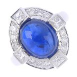 An 18ct gold sapphire and diamond cluster ring. The oval sapphire cabochon, with brilliant-cut