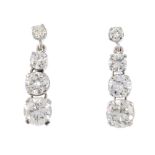 A pair of 14ct gold diamond earrings. Each designed as a graduated brilliant-cut diamond line,