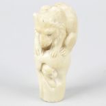 A Japanese Meiji period carved ivory cane handle, modelled with a seated bear attacking two