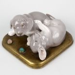 An unusual Royal Copenhagen figure group modelled as two playful puppies upon a gilt metal plinth