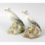 Two unusual E Radford pottery ornaments, each modelled as a seagull upon a rocky base, each with