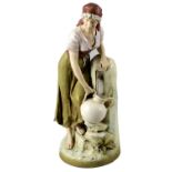 A large Royal Dux porcelain figure of a female water-carrier. Modelled in peasant dress with