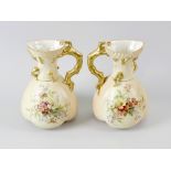 Four items of Royal Worcester blush ivory porcelain. Comprising: A pair of ewers or jug vases,