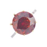 An 18ct gold garnet and diamond ring. The circular-shape orange spessartite garnet, with brilliant-