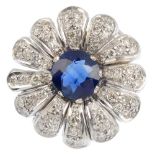 A sapphire and diamond floral cluster ring. The circular-shape sapphire, within a pave-set diamond