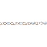 A 9ct gold topaz and diamond bracelet. Of bi-colour design, the oval-shape topaz, interspaced by