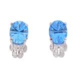 A pair of 18ct gold topaz and diamond earrings. Each designed as an oval-shape blue topaz, with