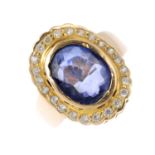 A synthetic sapphire and gem-set cluster ring. The oval-shape synthetic sapphire, within a