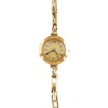 A lady's 1920s 18ct gold wristwatch. The circular cream dial, with black Arabic numerals, textured