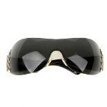 VERSACE - a pair of shield style sunglasses. The rimless grey tinted lenses, with polished silver-