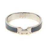 HERMÈS - a bangle. The hinged grey banded bangle, with silver-tone hardware clasp concealed behind