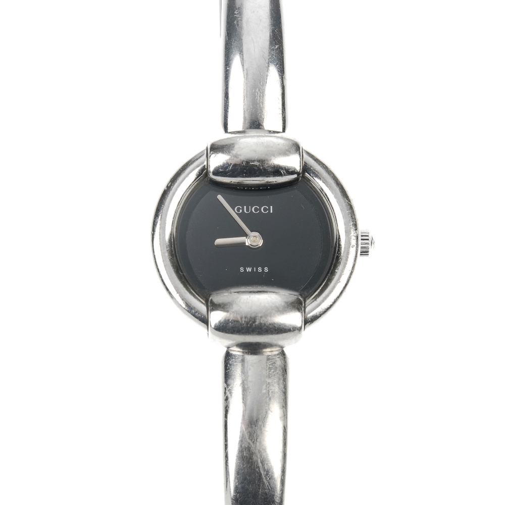 GUCCI - a stainless steel quartz lady's 1400L bangle watch. The plain black dial, with round case,