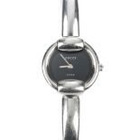 GUCCI - a stainless steel quartz lady's 1400L bangle watch. The plain black dial, with round case,
