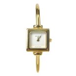 GUCCI - a lady's 1900 half bangle watch. Designed with a gold-tone square case with rounded corners,